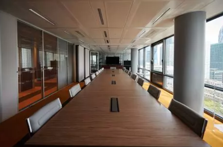 Fabricatie en installatie van maatmeubilair voor vergaderruimte – tafel en ingebouwde opbergruimtes